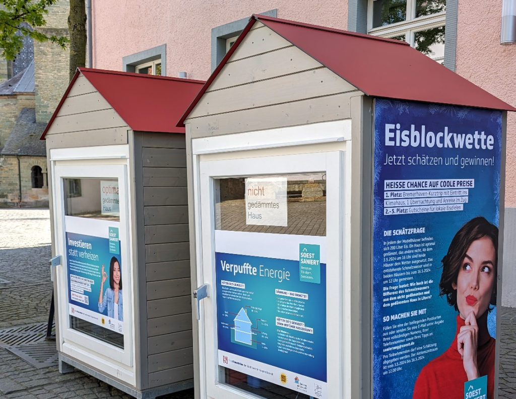 Zwei Häuschen mit Plakaten zum Sanierungsmanagement